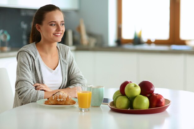 mujer joven, con, jugo de naranja, y, tableta, en, cocina