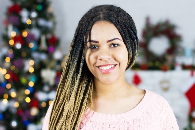 Mujer joven junto al árbol de Navidad