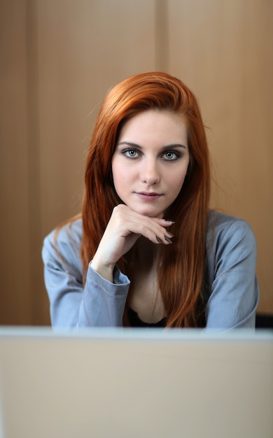 Mujer joven junto a la computadora portátil