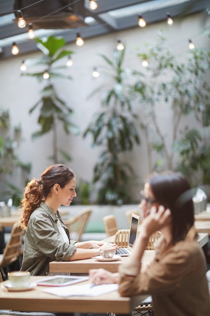 Mujer joven con laptop en café