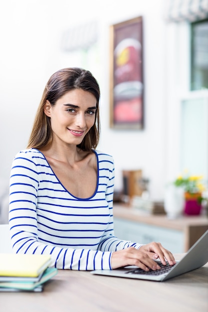 Mujer joven con laptop en la mesa