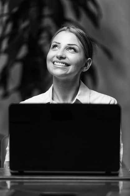 Mujer joven con laptop en la oficina