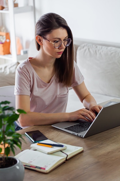 Mujer joven con laptop para trabajar en casa