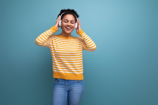 Mujer joven latina afro enérgica bailando música con auriculares