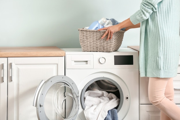 Mujer joven lavando ropa en casa