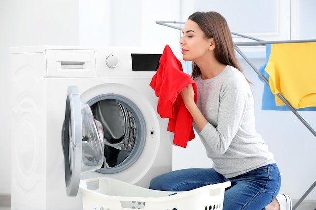 Mujer joven lavando ropa en casa