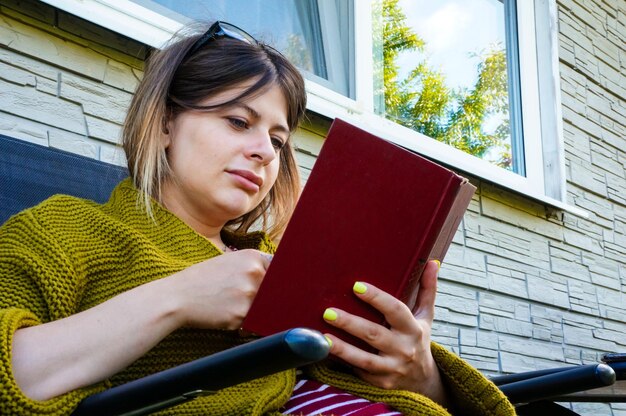 Foto mujer joven lee un libro libro en manos de mujeres