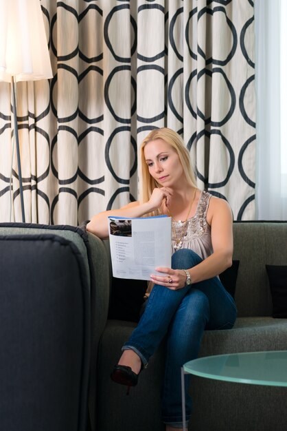 Mujer joven, leer una revista, en, habitación de hotel