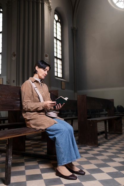 Mujer joven leyendo la biblia en la iglesia