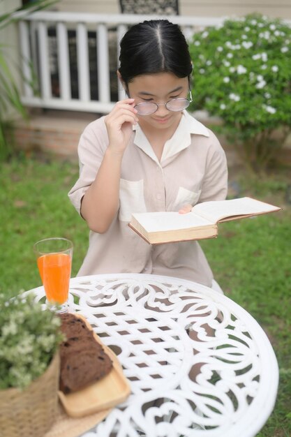 Mujer joven leyendo un libro al aire libre