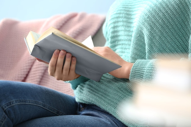 Mujer joven, libro de lectura, en casa, primer plano