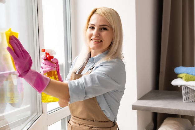 Mujer joven limpiando la ventana