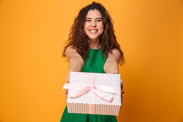 Foto mujer joven linda que sostiene la actual caja de regalo.