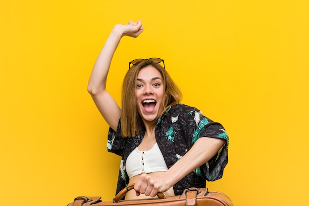 Mujer joven lista para ir de vacaciones sobre fondo amarillo