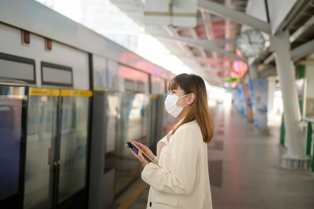 Una mujer joven lleva una máscara protectora en el metro, protección covid-19, viajes de seguridad, nueva normalidad, distanciamiento social, transporte de seguridad, viajes bajo el concepto de pandemia