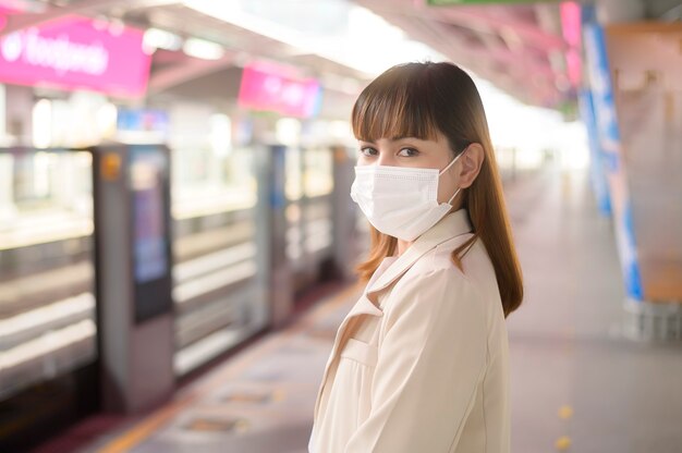 Una mujer joven lleva una máscara protectora en el metro, protección covid-19, viajes de seguridad, nueva normalidad, distanciamiento social, transporte de seguridad, viajes bajo el concepto de pandemia