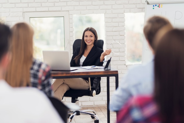 Foto mujer joven está llevando a cabo un seminario sobre pnl entre los visitantes.