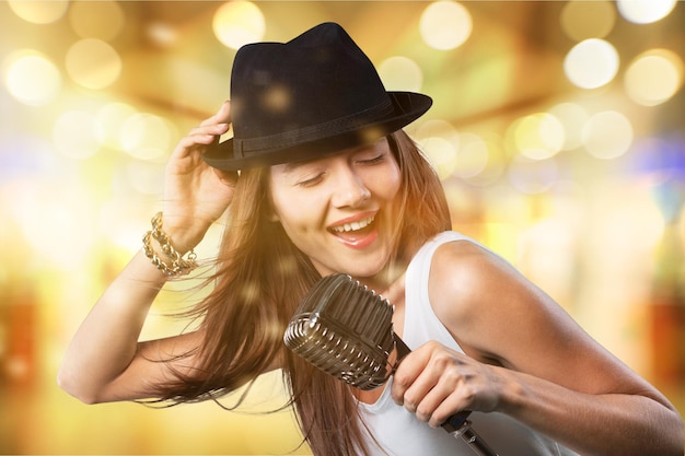 Foto mujer joven, llevando, sombrero, canto, en, micrófono