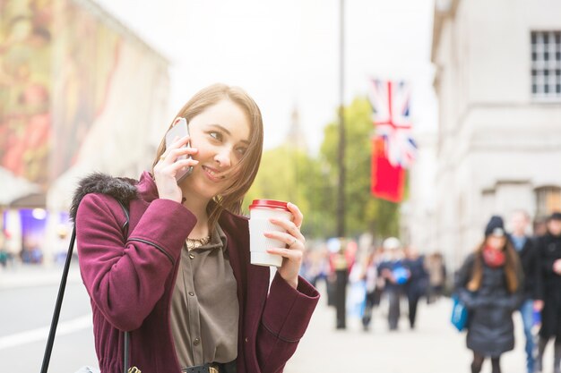 Foto mujer joven en londres hablando por teléfono