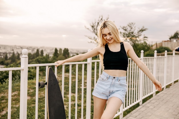 Mujer joven con longboard al aire libre