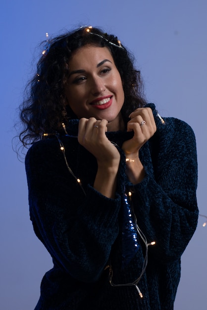 Mujer joven con luces brillantes de Navidad Celebración.