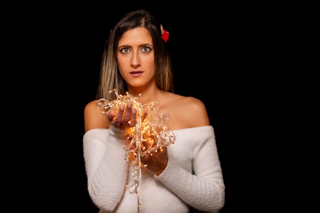 Foto mujer joven con luces de navidad