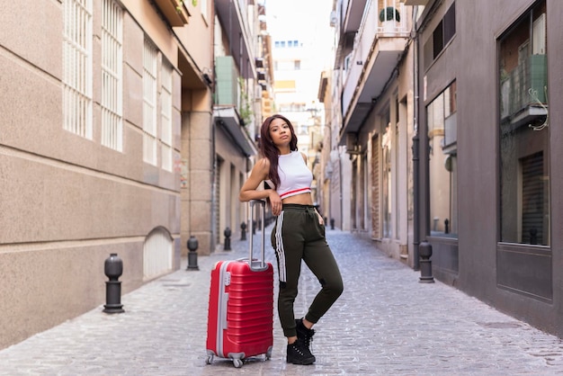 mujer joven, con, maleta, ambulante, en, calle