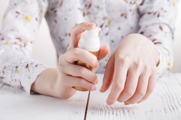 Mujer joven manos aplicando crema hidratante para la piel