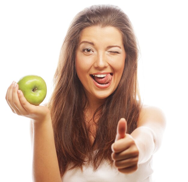 Mujer joven con manzana verde y mostrando el pulgar hacia arriba