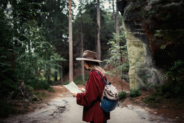 Foto mujer joven con mapa en las montañas