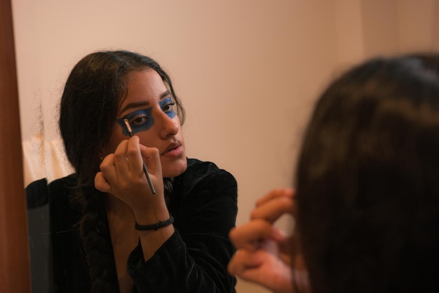 Mujer joven se maquilla para disfrazarse para el día de los muertos en México