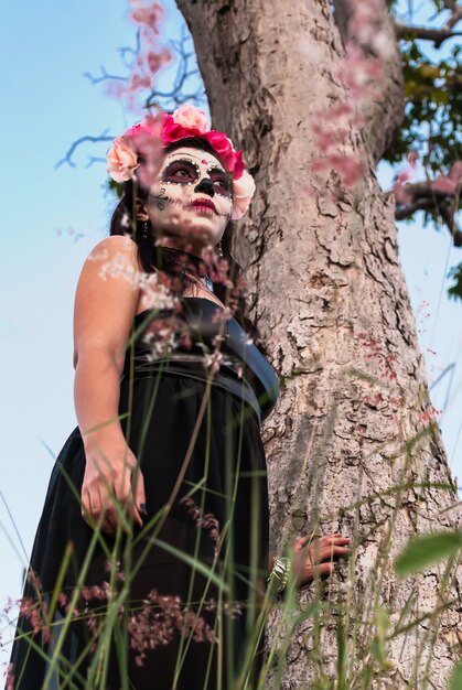 Mujer joven con maquillaje de calavera de azúcar Día de Muertos