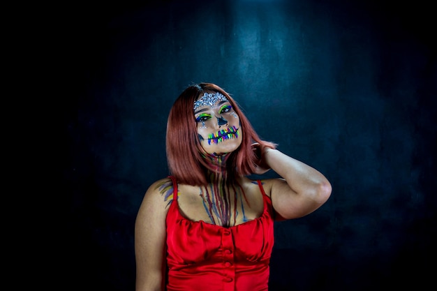 Mujer joven con maquillaje para fiesta de halloween fiesta de disfraces fondo negro y blusa roja