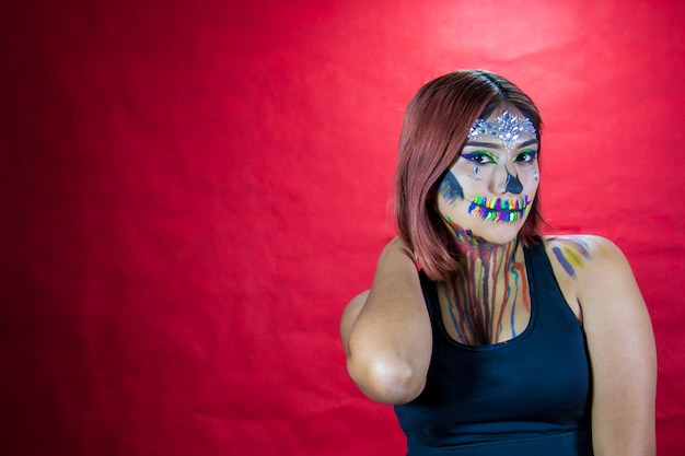 Mujer joven con maquillaje para fiesta de halloween fiesta de disfraces fondo rojo