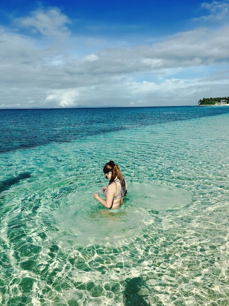 Mujer joven en el mar en un día soleado