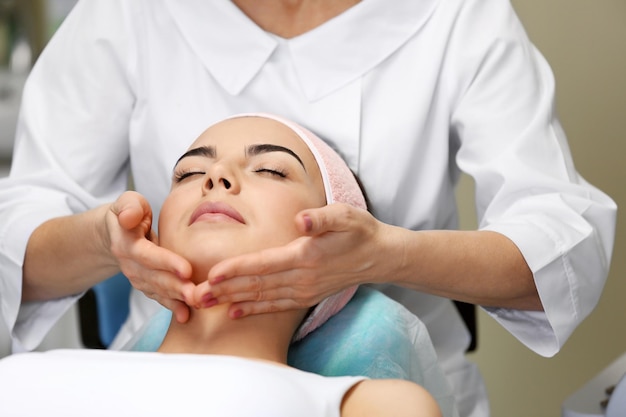 Mujer joven con masaje facial en un salón de belleza