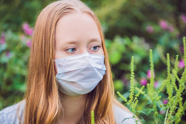 Mujer joven con una máscara médica debido a una alergia a la ambrosía