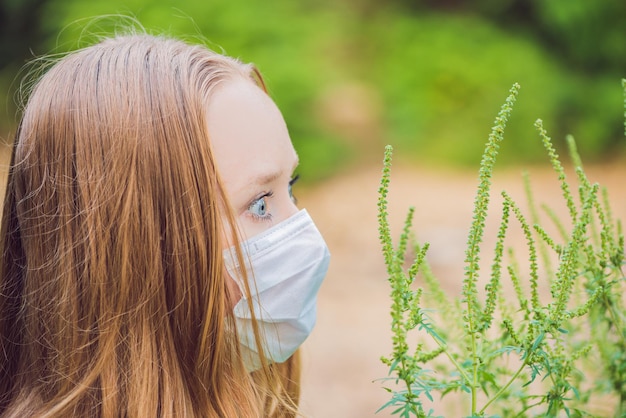 Foto mujer joven con una máscara médica debido a una alergia a la ambrosía