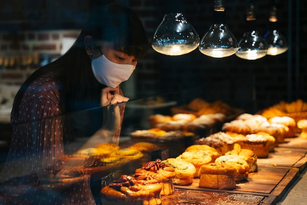 Mujer joven con máscara mirando comida en la tienda