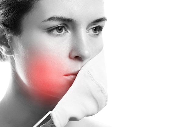 Foto mujer joven con máscara de prevención e irritación de la piel sobre fondo blanco. maskne: brotes de acné por el uso de una mascarilla.