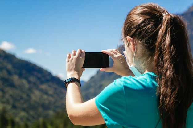 Mujer joven con una máscara tomando fotos