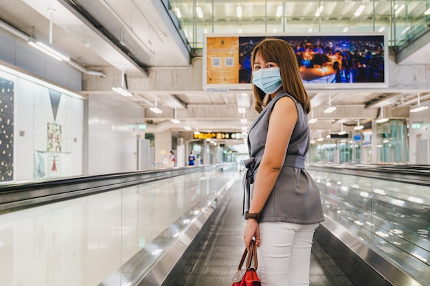 Mujer joven con mascarilla en el aeropuerto de Tailandia