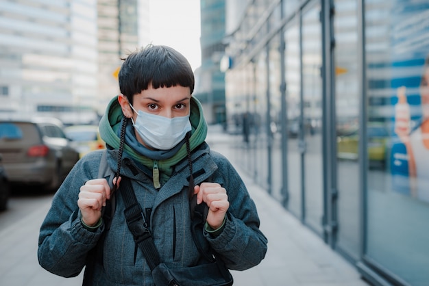 Mujer joven con mascarilla en las calles. Protección contra el coronavirus