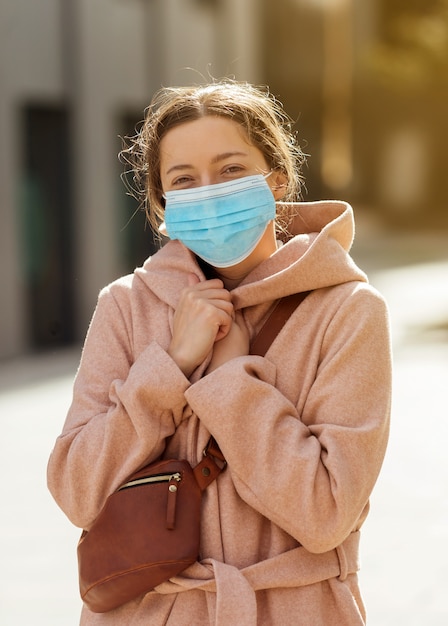 Foto mujer joven con mascarilla protectora al aire libre