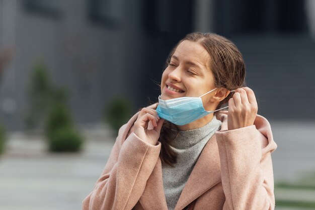 Mujer joven con mascarilla protectora al aire libre