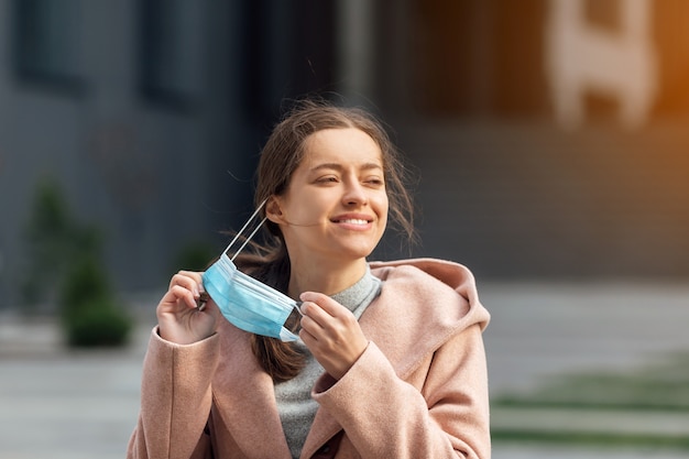 Mujer joven con mascarilla protectora al aire libre