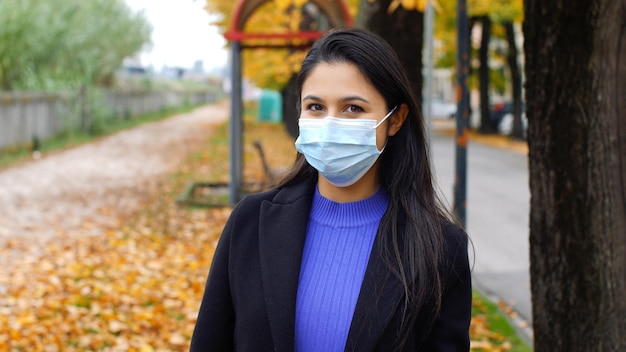 Mujer joven con mascarilla quirúrgica en tiempos de la pandemia de Covid19