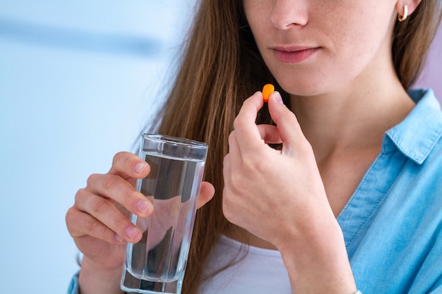 Foto mujer joven de medicina tomando pastillas y vitaminas para desastres de tratamiento y bienestar. suplemento dietético y cuidado de la salud.