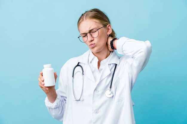 Mujer joven médico ruso que sostiene la botella de píldoras en azul que sufre dolor de cuello debido al estilo de vida sedentario.