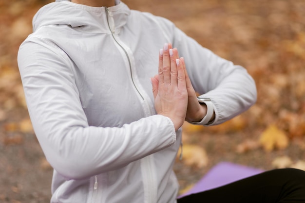 Mujer joven meditando en el bosque de otoño